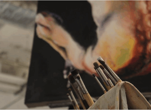 Paint brushes in front a painting