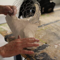two hands forming a paper mache work