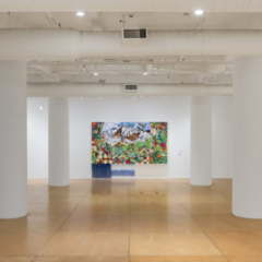 Exhibition view of a gallery with a single painting on the back wall flanked by two white columns on each side.