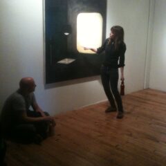 Student standing in front of a work and gesturing towards it.